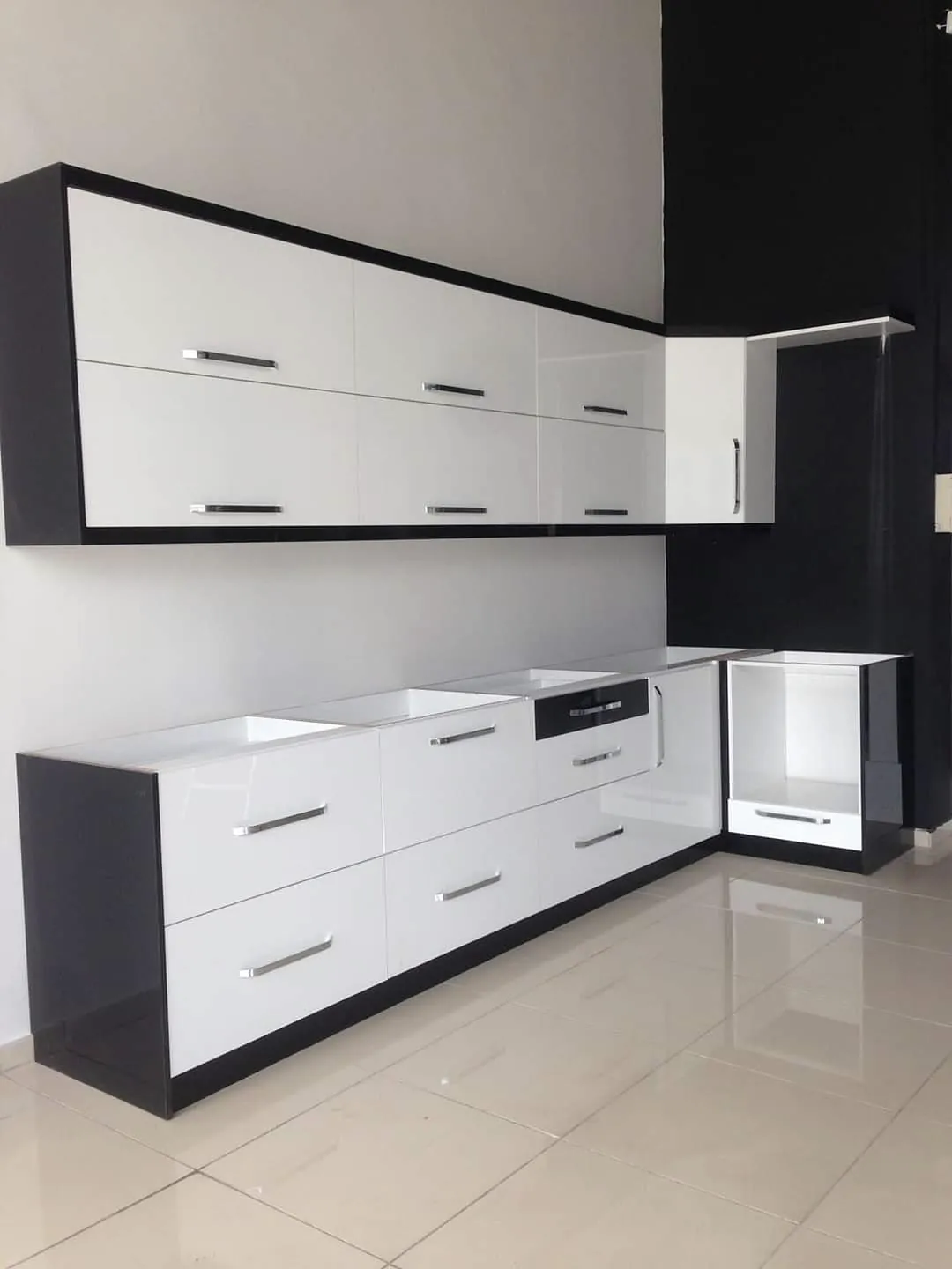 Black and white modular kitchen with long drawer units, wall cabinets and a dark worktop