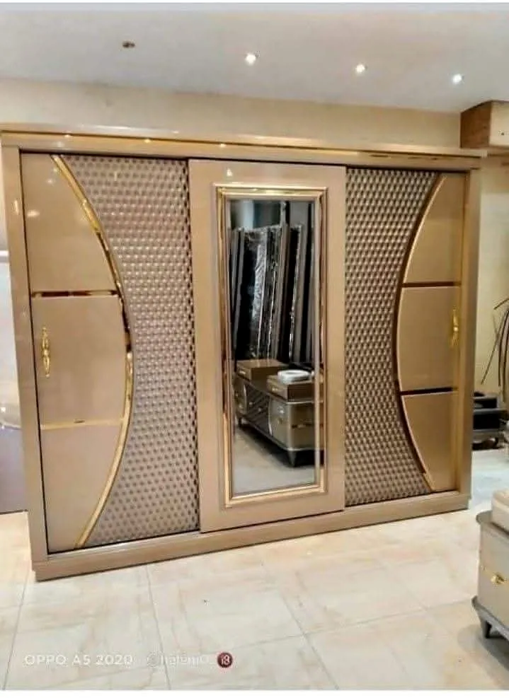 Champagne-toned wardrobe with a central dressing mirror and curved decorative panels