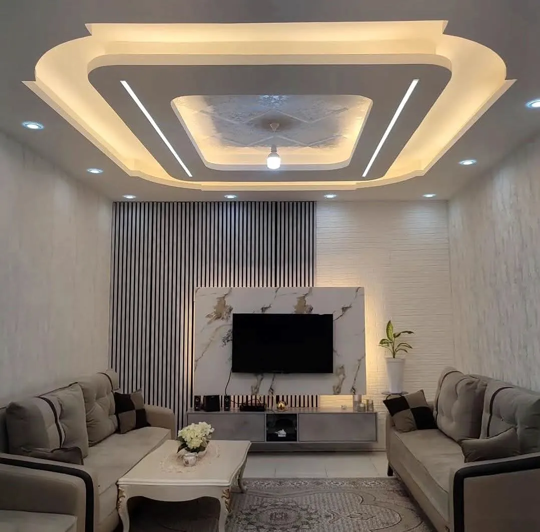 Completed Mumbai living room with facing sofas, a centred television wall and layered false ceiling