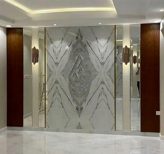 Symmetrical grey-veined feature wall with metallic trim, wall lights and timber doors