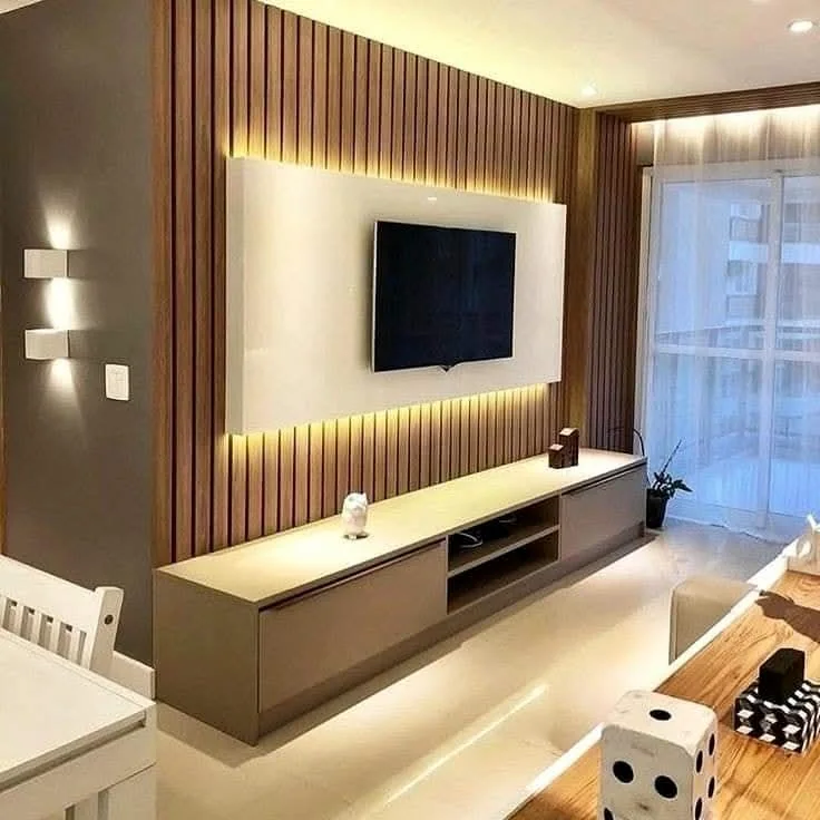 Photographed Mumbai living room with a warm backlit television wall and timber storage