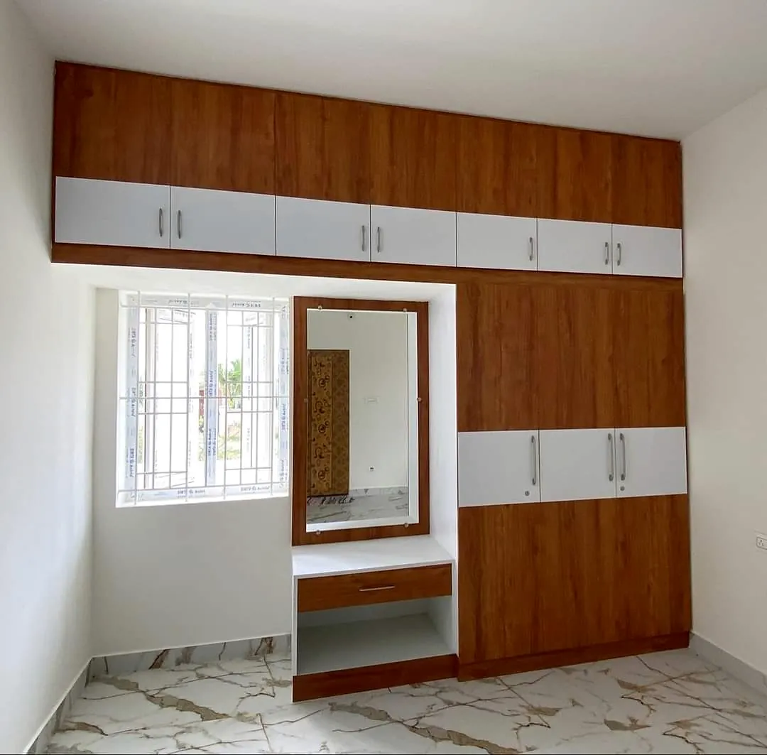 timber and white wardrobe arranged around a bedroom window with dressing mirror