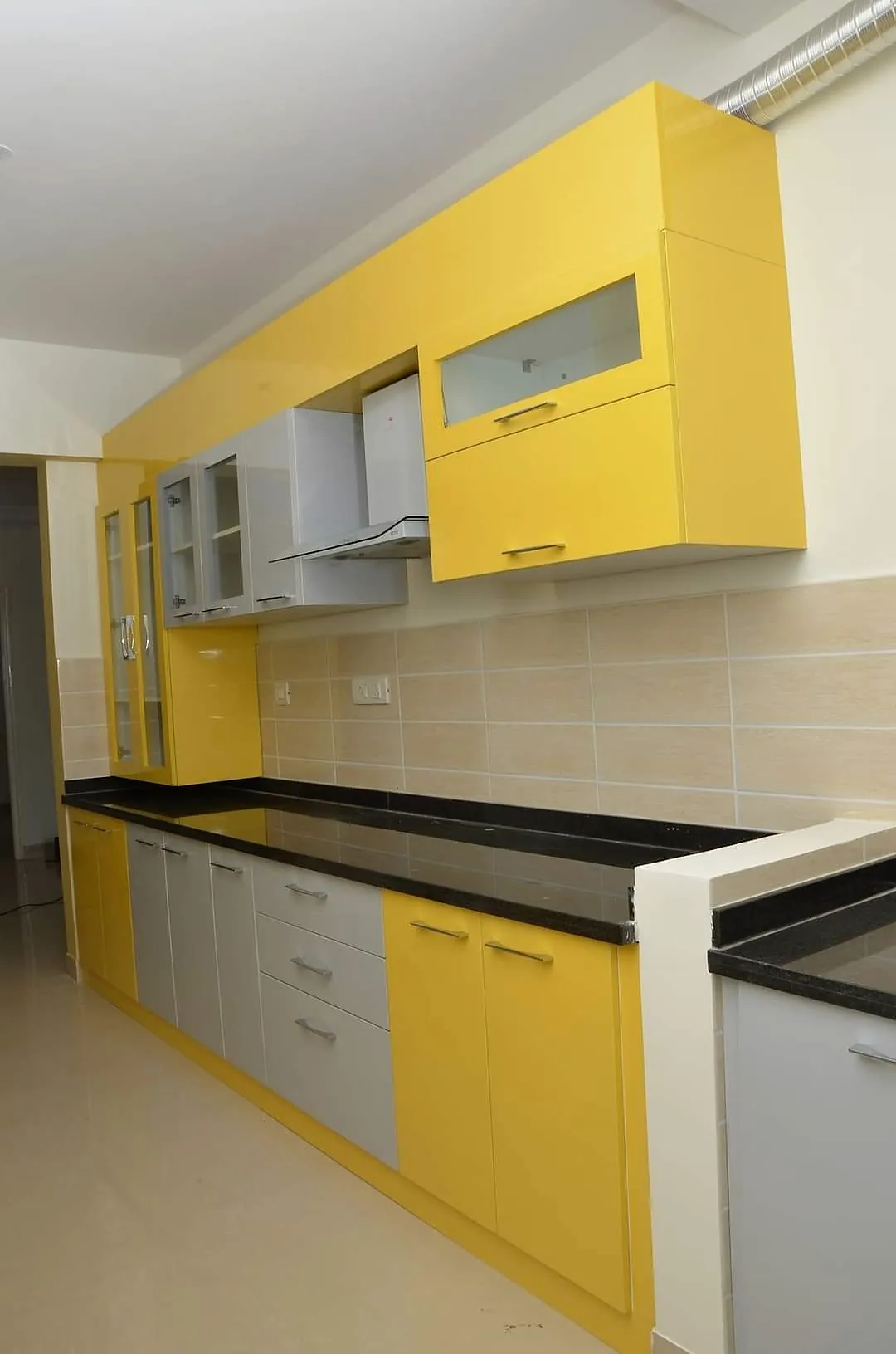 compact kitchen with yellow and grey cabinets and black worktop
